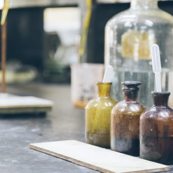 detail shot of beakers and equipment on table in factory laboratory.