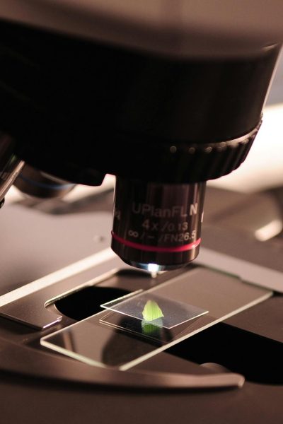 Detailed view of a microscope with a slide in a laboratory environment.